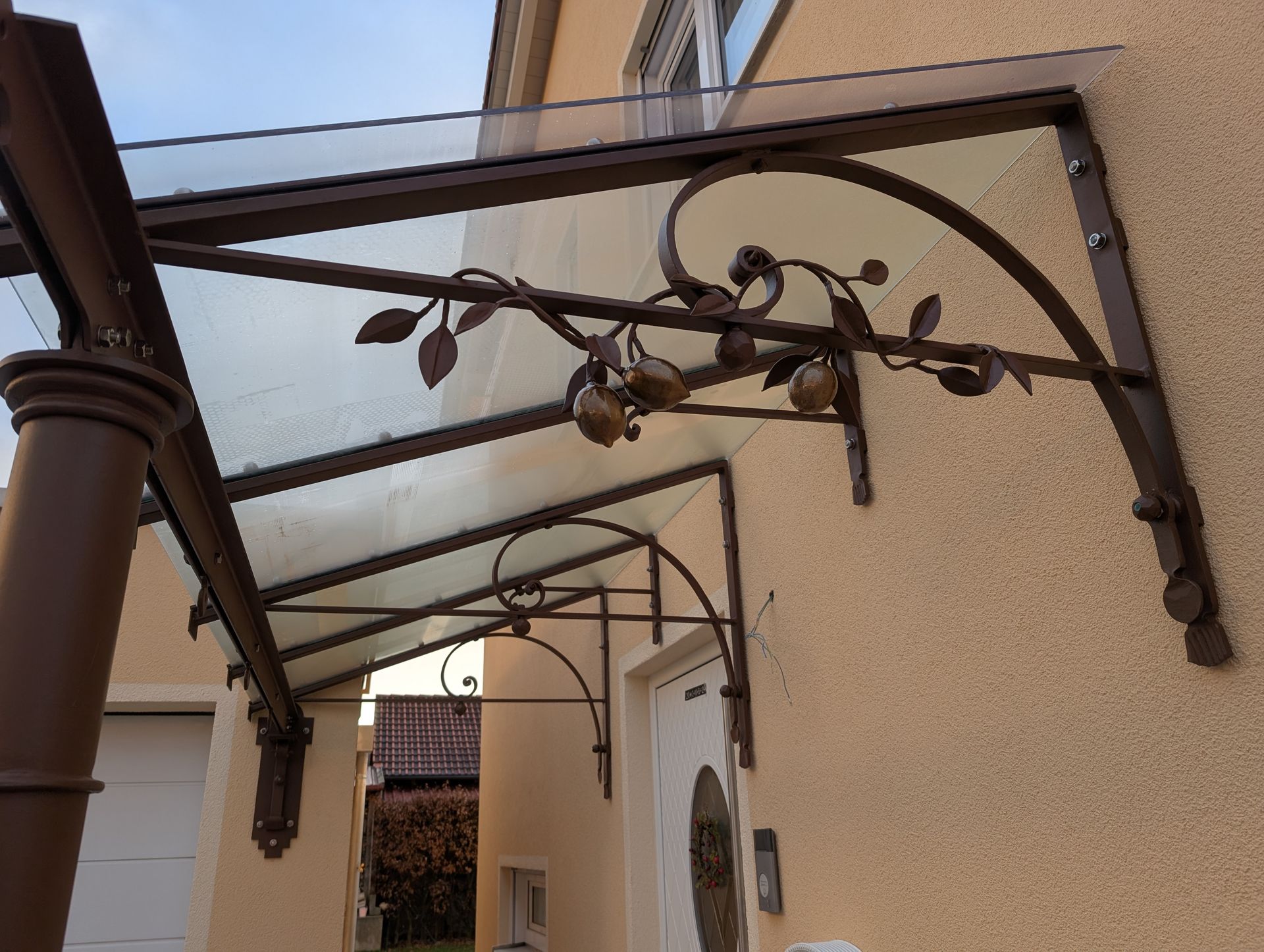 Detail einer Metallüberdachung mit dekorativen Rankelementen