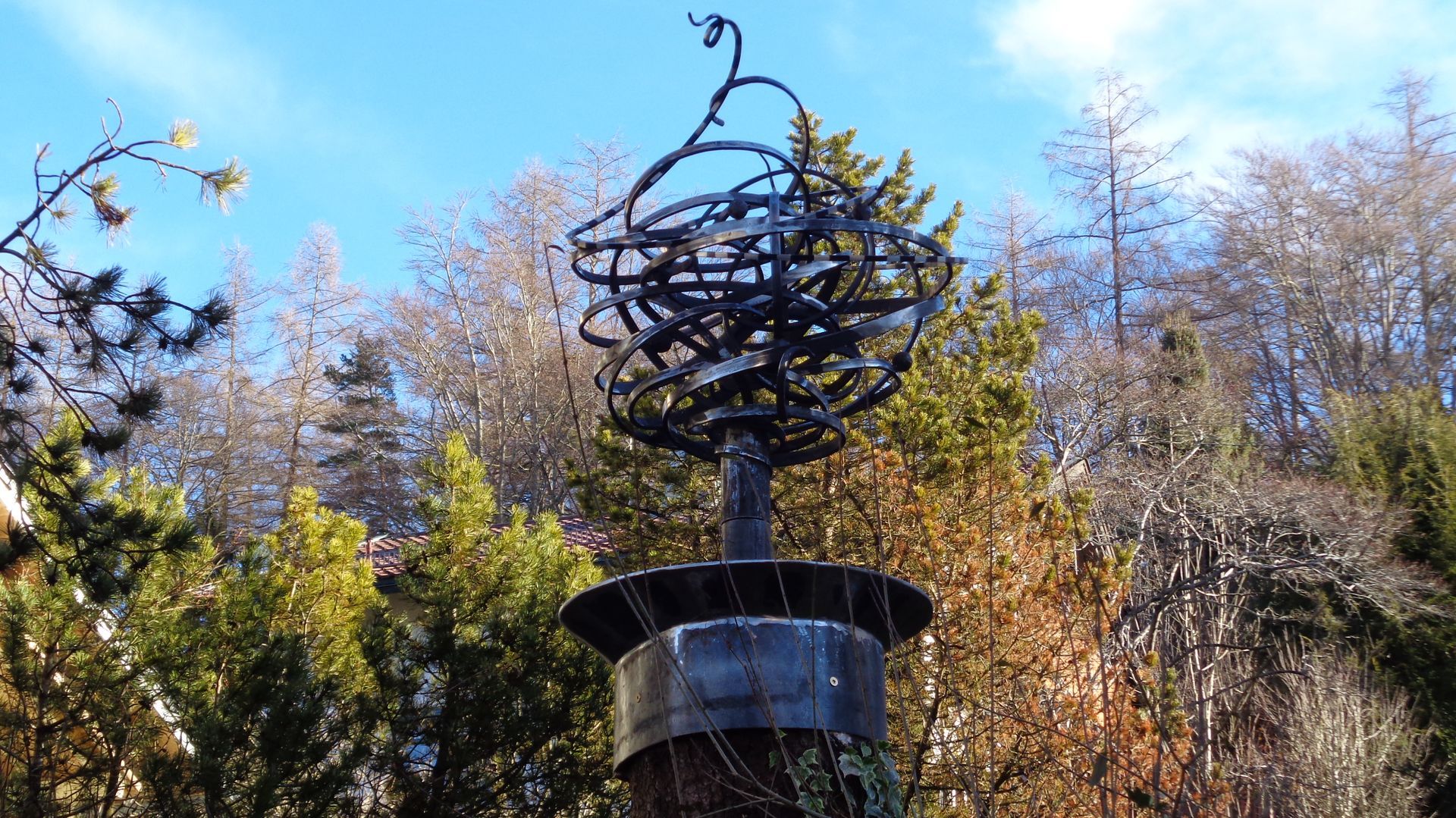 Metallskulptur mit spiralförmiger Struktur im Garten