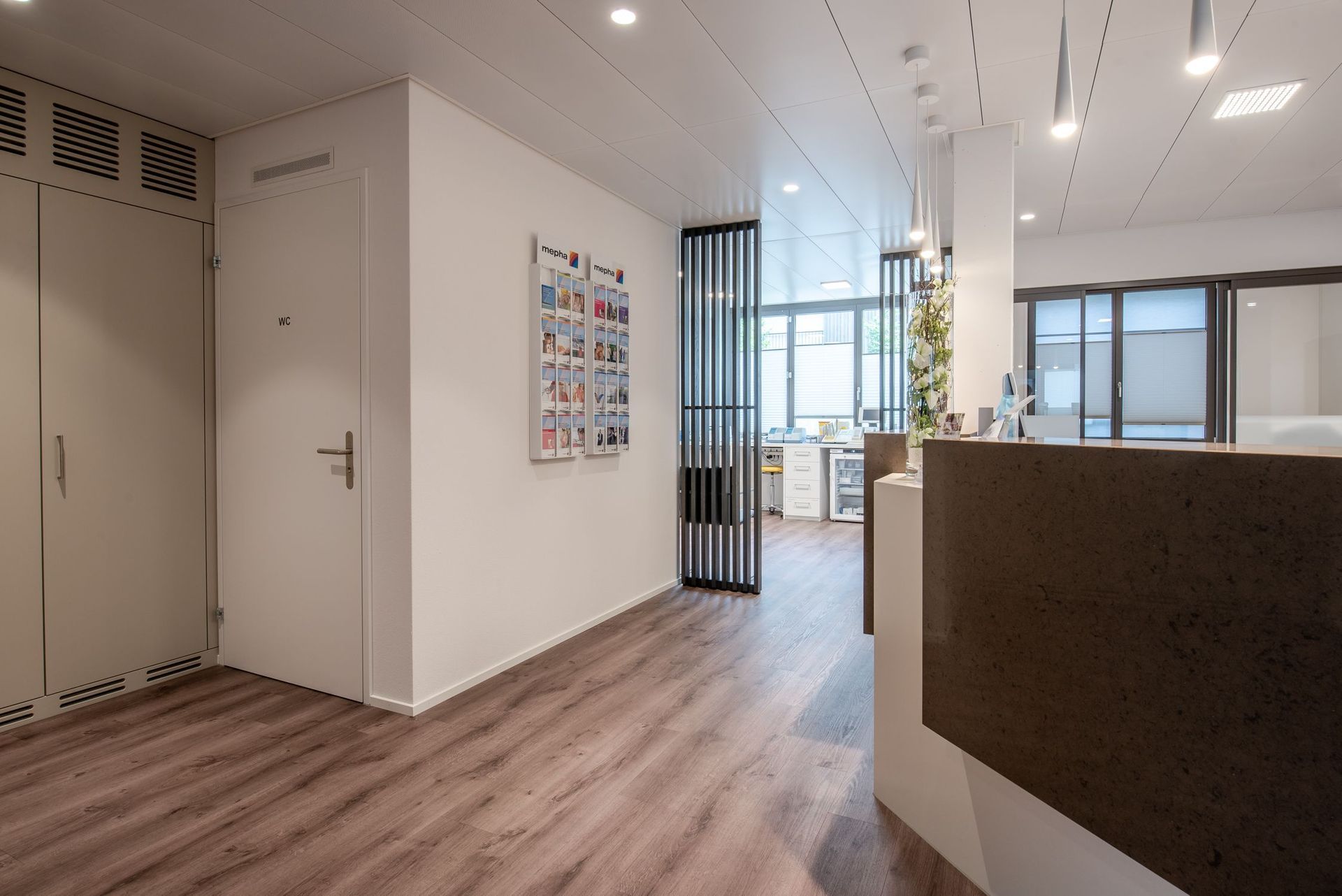 Ein Flur mit Holzboden und einer Rezeption in einem Gebäude.