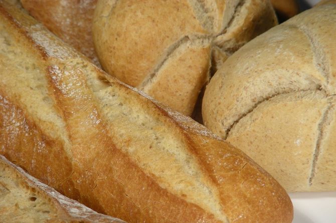 Un montón de diferentes tipos de pan están en un plato blanco.