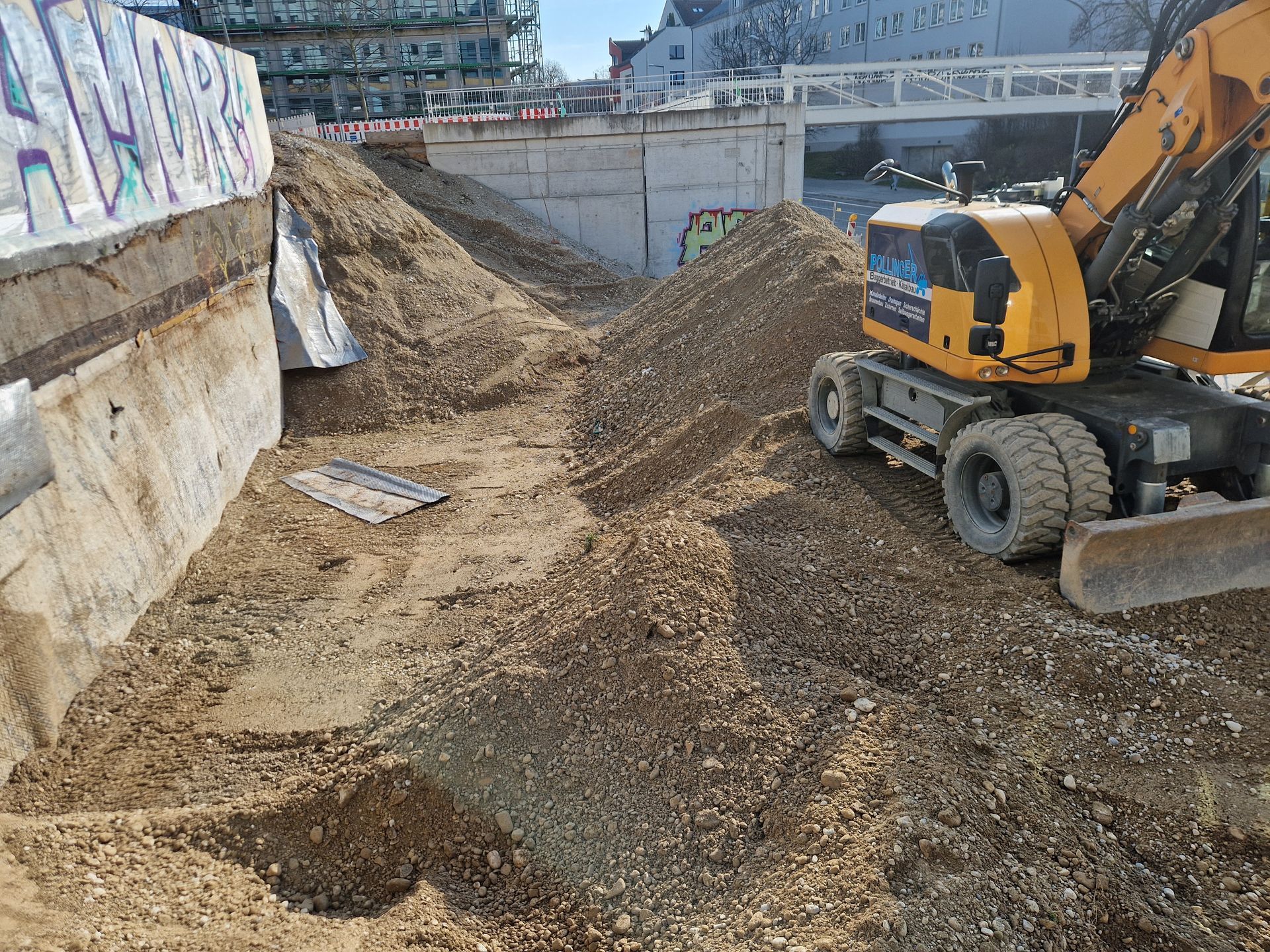 Ein Bagger schaufelt etwas an einem See
