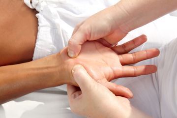 Ansicht eines Bauches, der mit Moxibustion behandelt wird, wobei eine Hand das entsprechende Utensil über dem Bauchnabel hält.