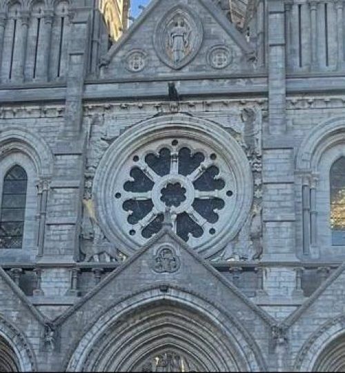Fachada de catedral de piedra gris con rosetón.
