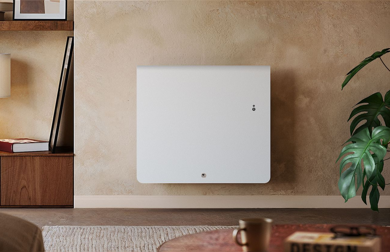 Un radiateur blanc minimaliste fixé sur un mur beige texturé dans un salon moderne, avec une plante et une table basse à proximité.