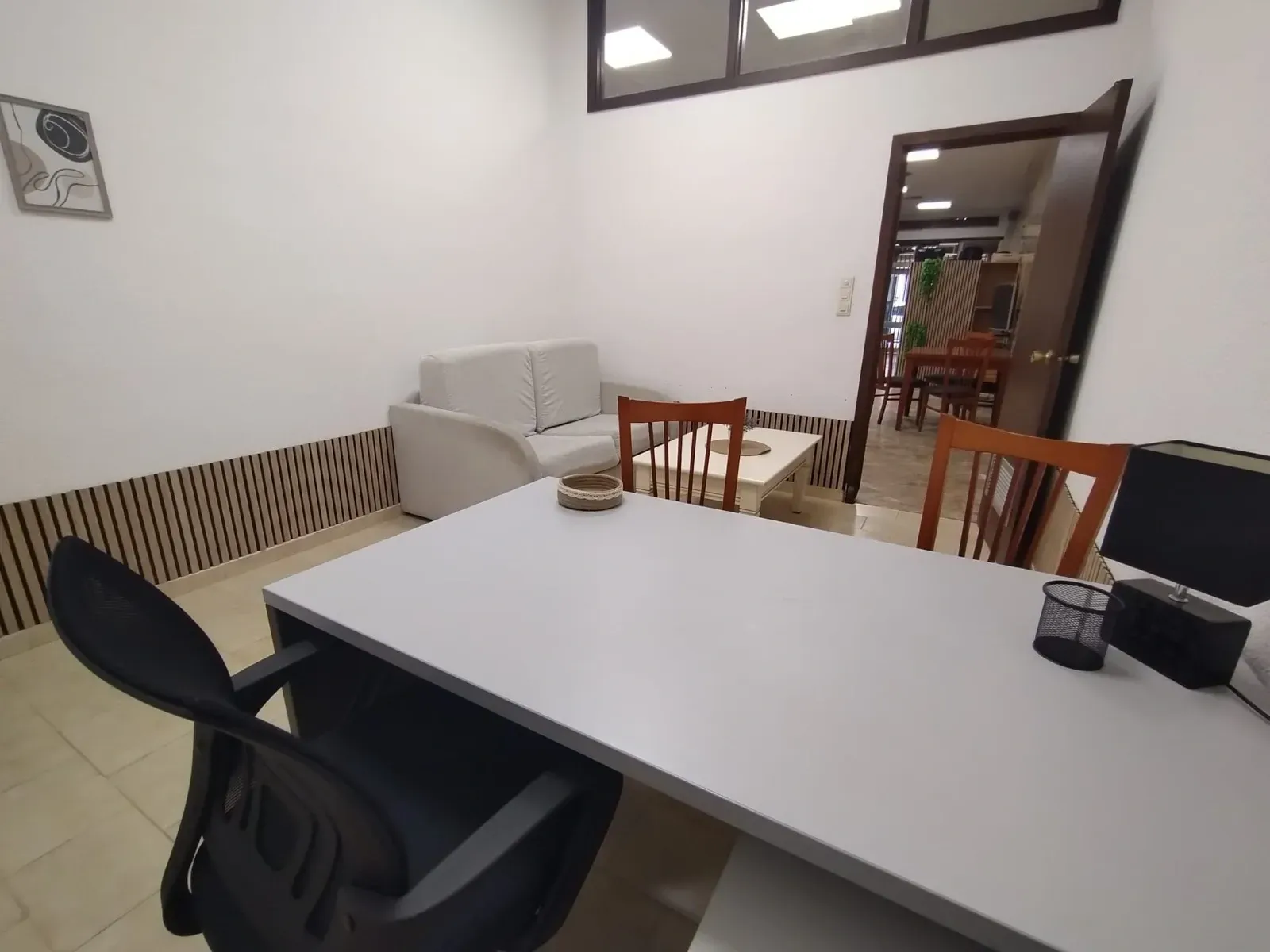 Un interior de oficina moderno con un escritorio gris claro