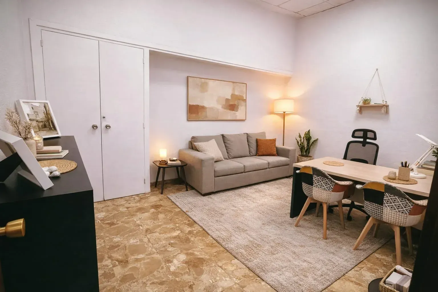 Una oficina en tonos neutros con un sofá gris