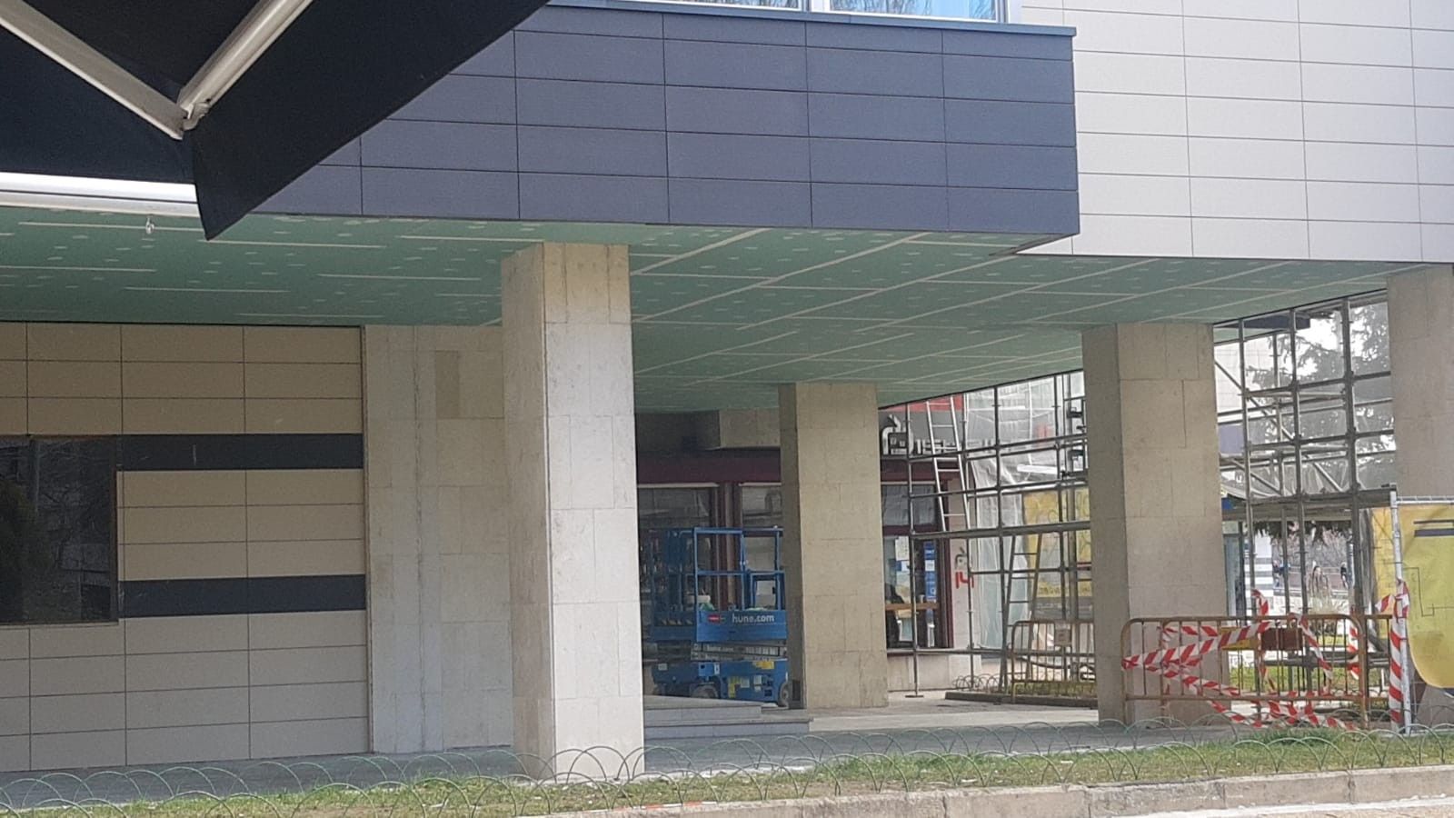 Edificio parcialmente construido con pilares de hormigón, paredes revestidas de azulejos y andamios delante