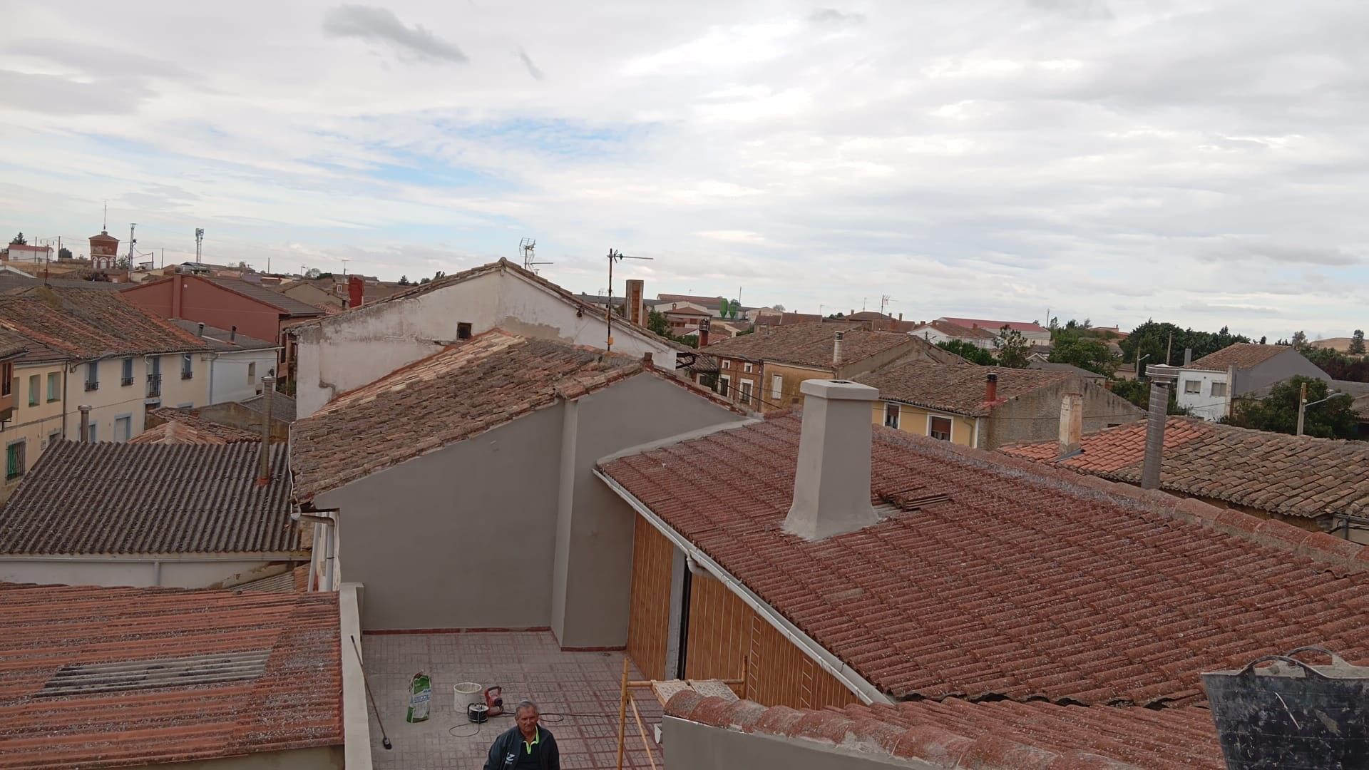 Tejados de un barrio residencial con tejas rojas bajo un cielo nublado