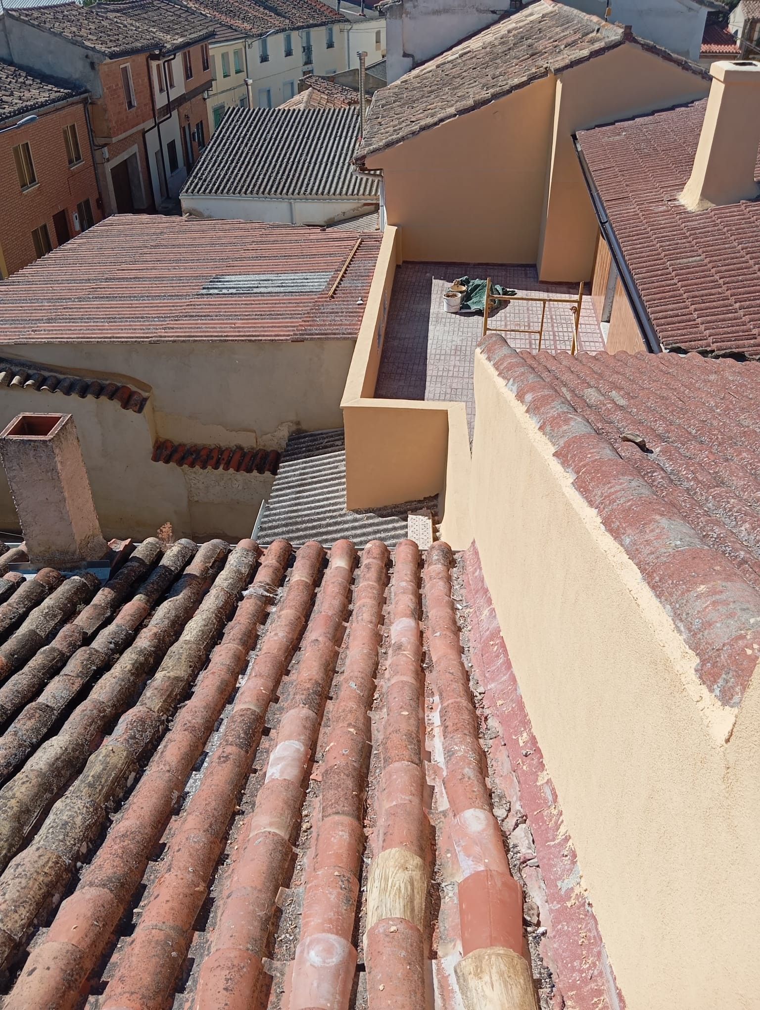 Tejados con tejas de terracota y paredes beige en un barrio densamente poblado en una ladera.