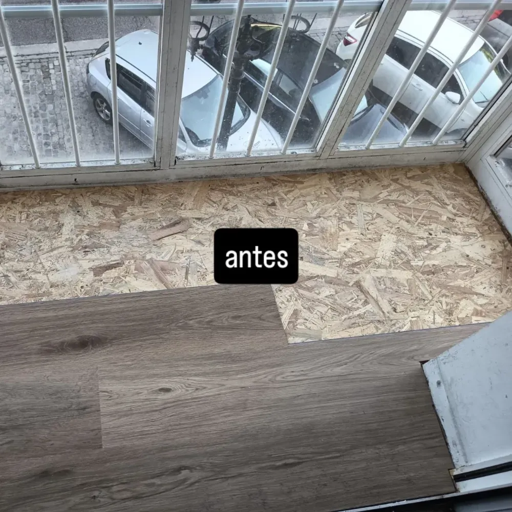 Se están realizando trabajos de reparación del suelo junto a la ventana de un balcón, donde se puede apreciar el antiguo aglomerado y el nuevo laminado de madera.