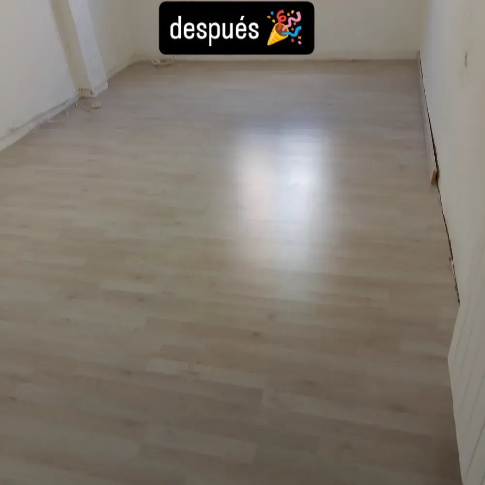 Habitación vacía con suelo de madera clara, paredes blancas y una etiqueta que dice
