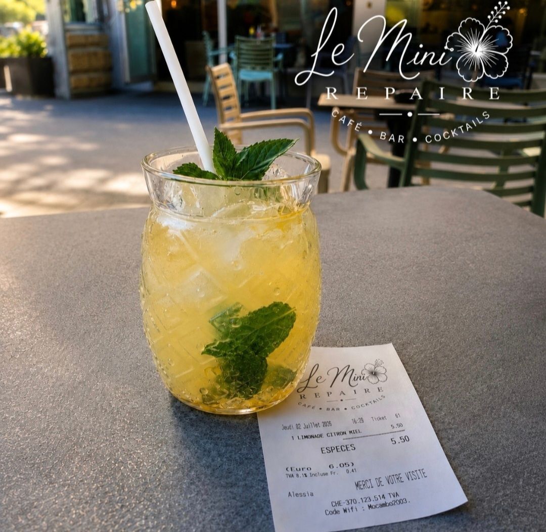 Boisson à la menthe jaune dans un bocal Mason avec une paille, posée sur la table d'un café, à côté d'un ticket de caisse.