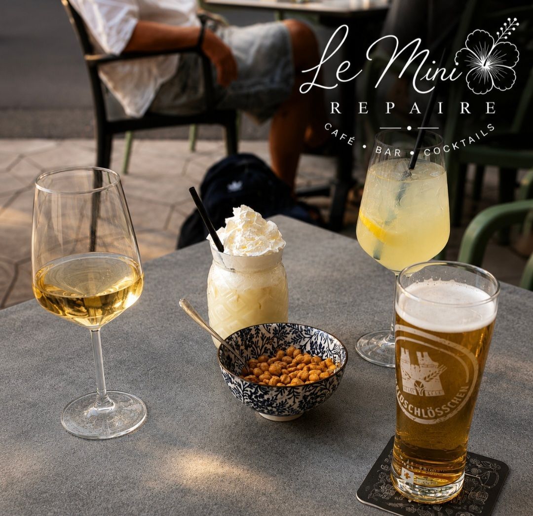 Boissons et en-cas sur une table de café : bière, vin, cocktails et un bol de noix sur des sous-verres.