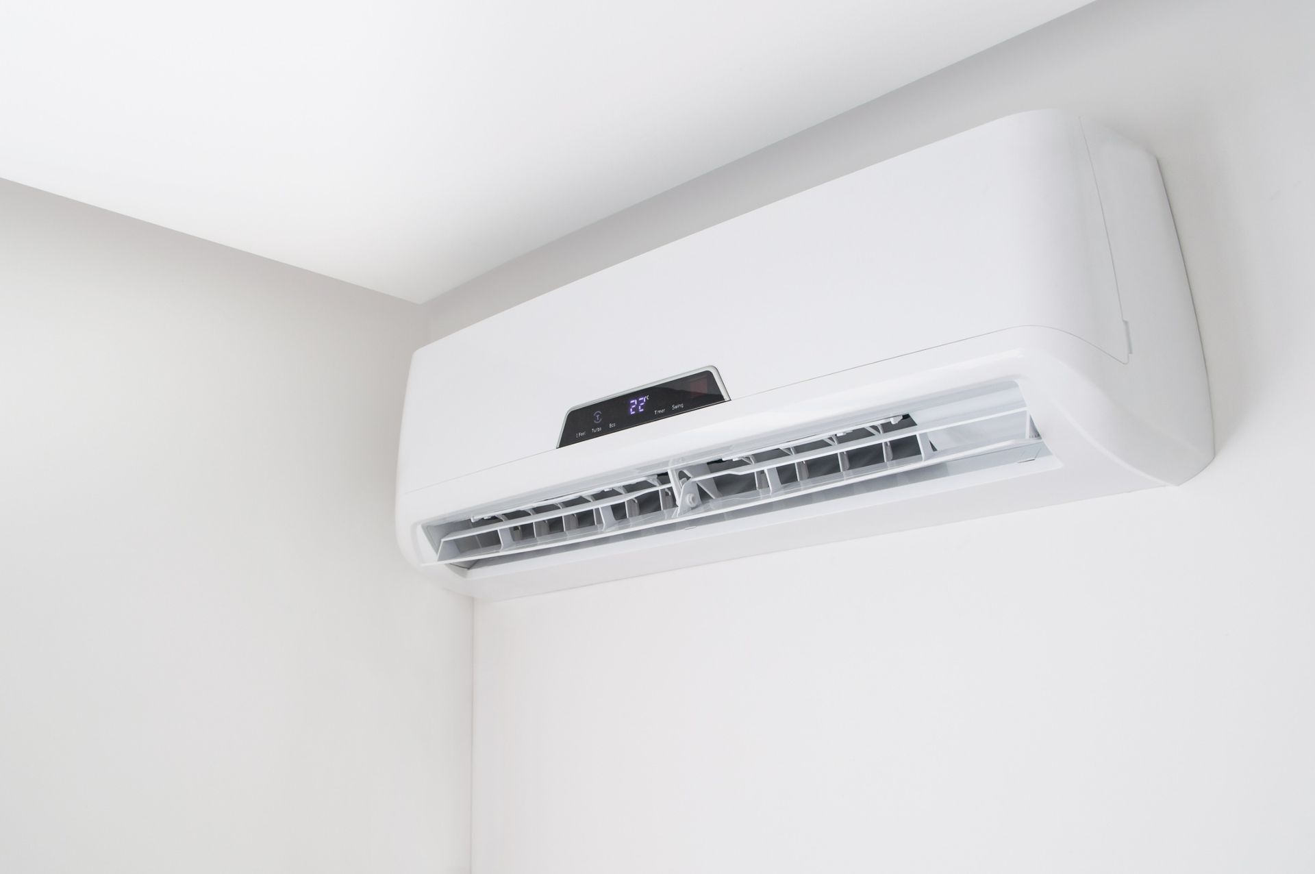Un acondicionador de aire blanco cuelga del techo de una habitación.