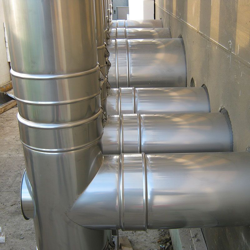 Eine Reihe von Edelstahlrohren ist an einer Wand aufgereiht