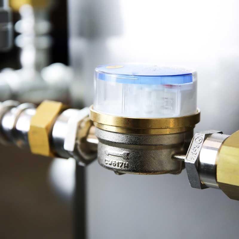 Eine Nahaufnahme von einem Wasserzähler an einem Rohr