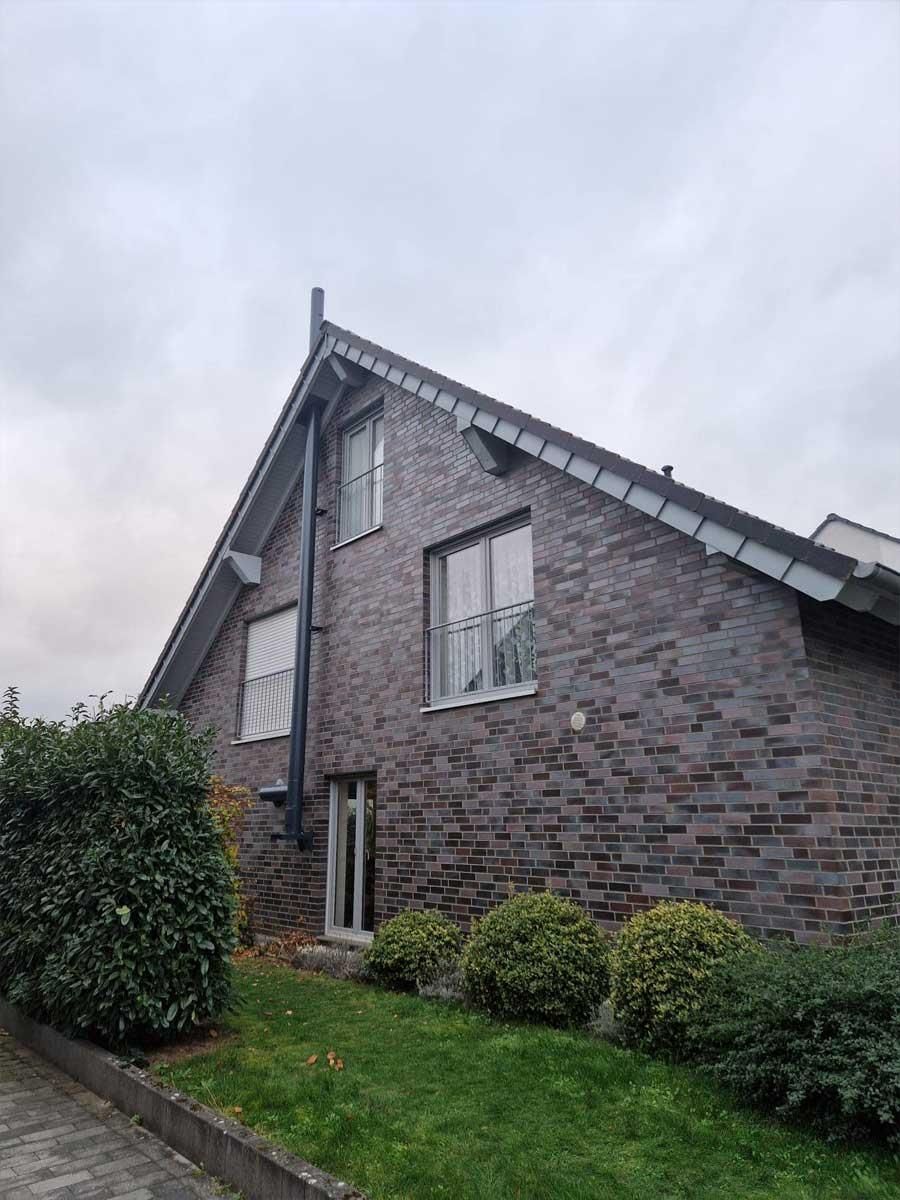 Ein großes Backsteinhaus mit schrägem Dach und vielen Fenstern