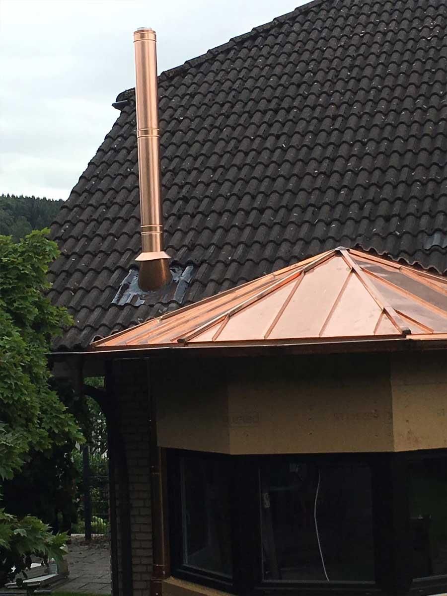 Ein Haus mit einem Kupferkamin darauf