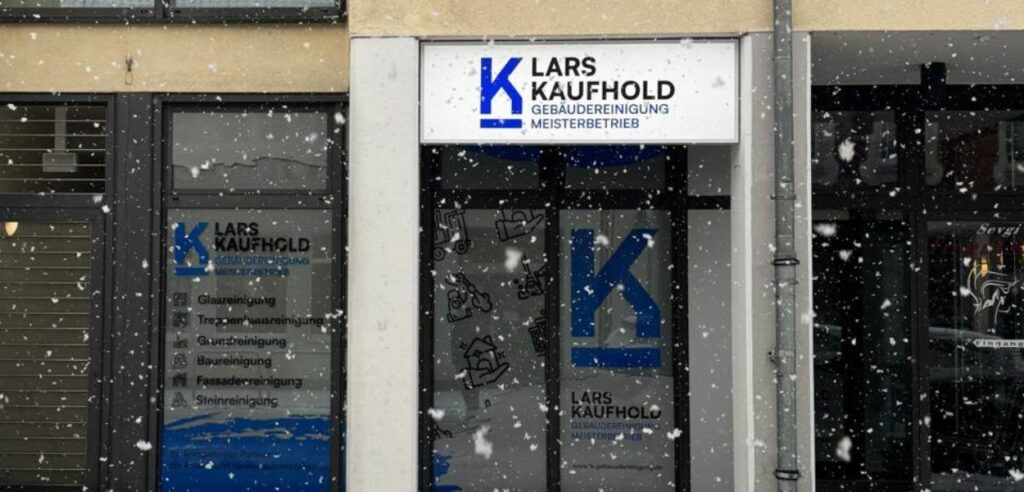 Verschneite Ladenfront mit einem Schild, auf dem „Lars Kaufhold“ steht.