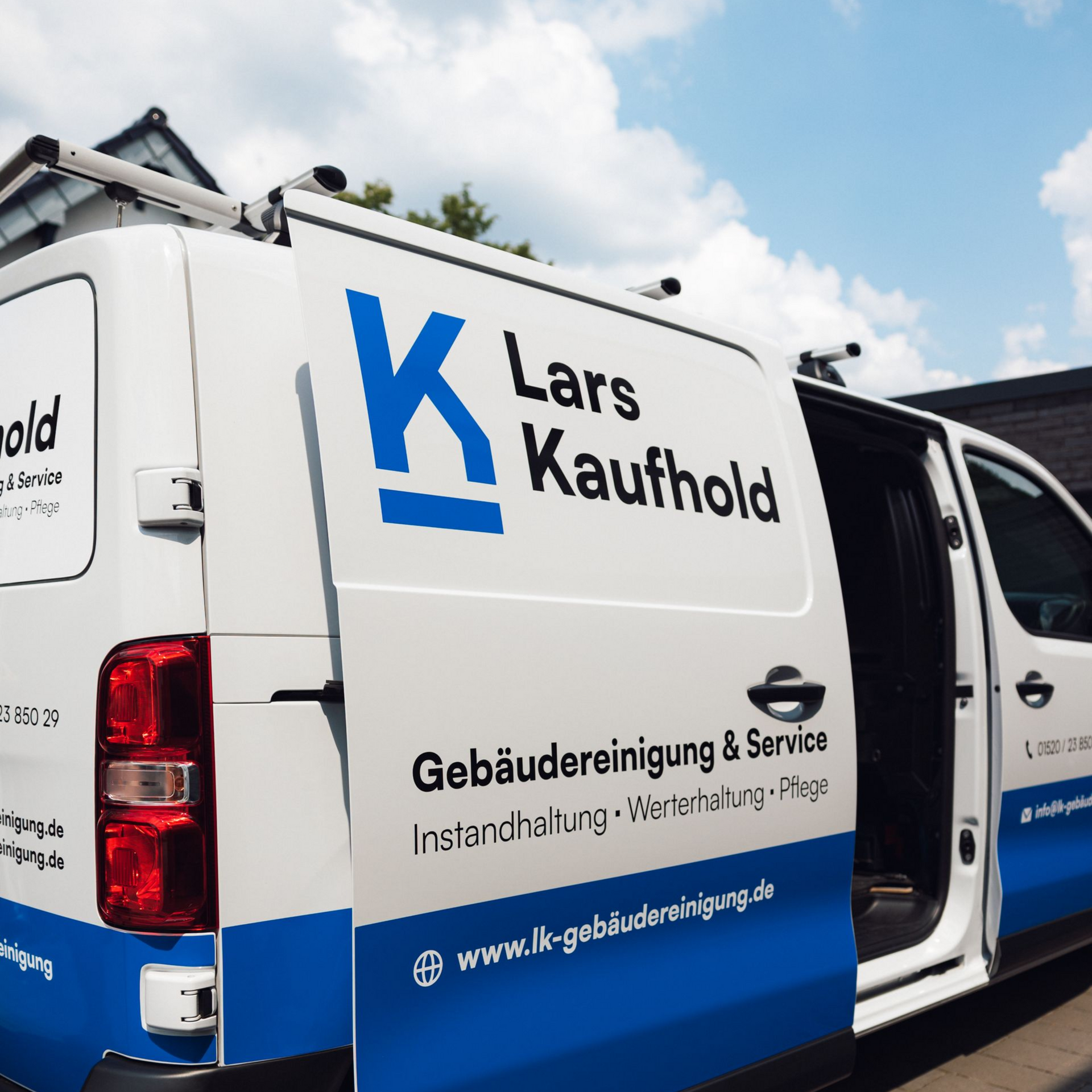 Lars Kaufhold belädt einen Eimer mit Reinigungsmitteln aus einem Lieferwagen. Außenaufnahme am Tag.