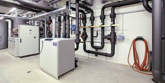 Ein Raum mit vielen Rohren und einem Boiler darin.