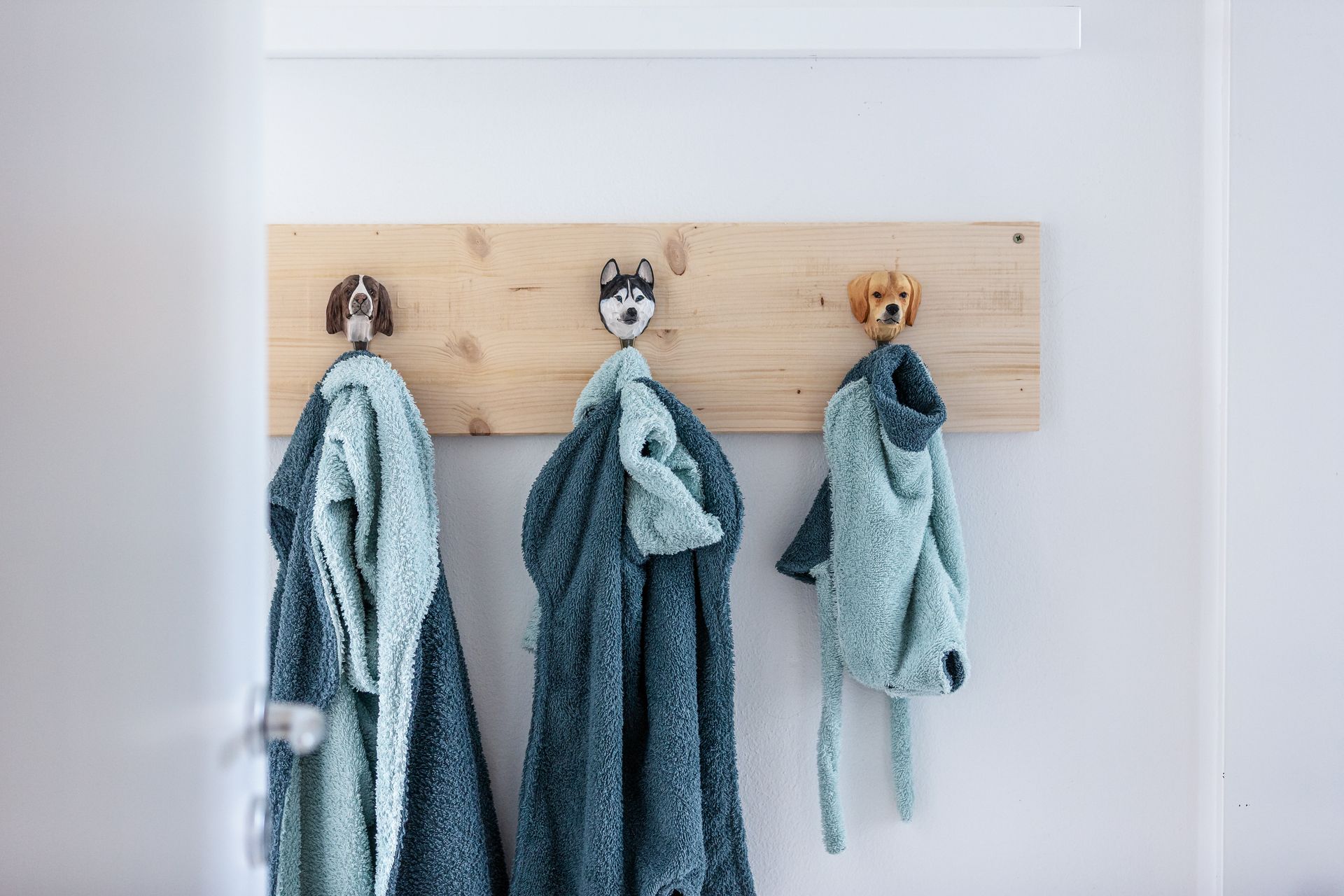 Kleiderhaken mit Hundeköpfen und Kleidungsstücken für Hunde