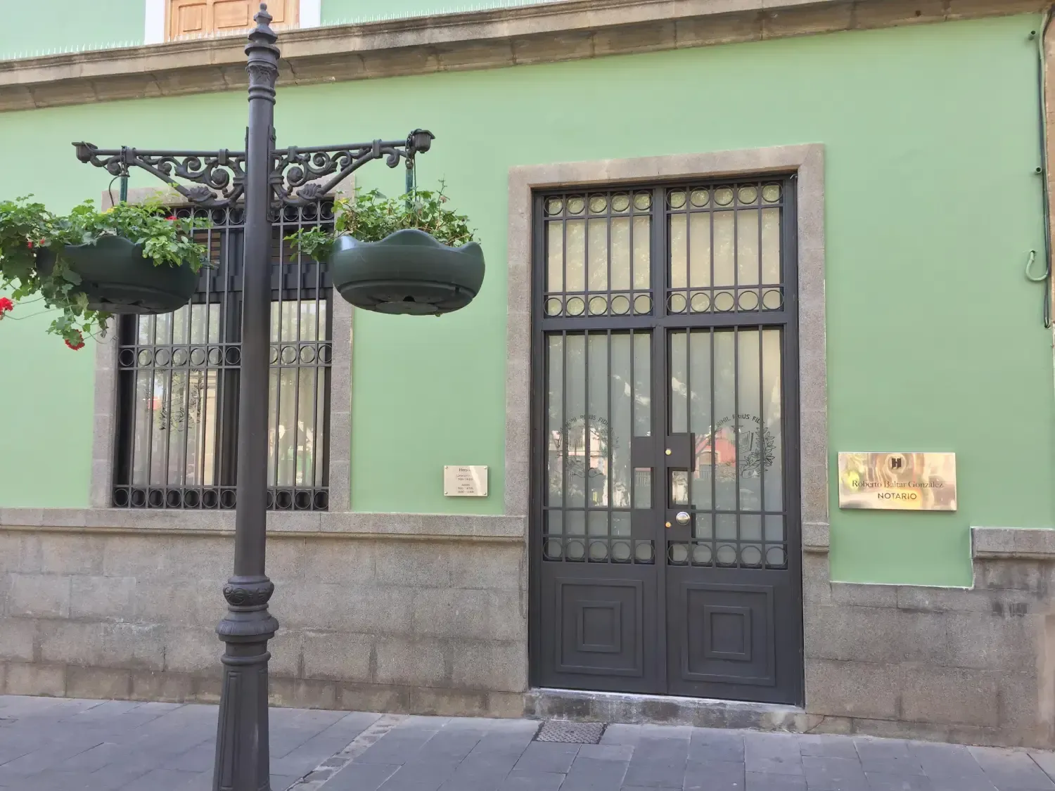 Una sala de reuniones con una mesa de cristal, sillas negras y portátiles.