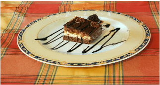Un plato blanco con un trozo de pastel de chocolate encima.