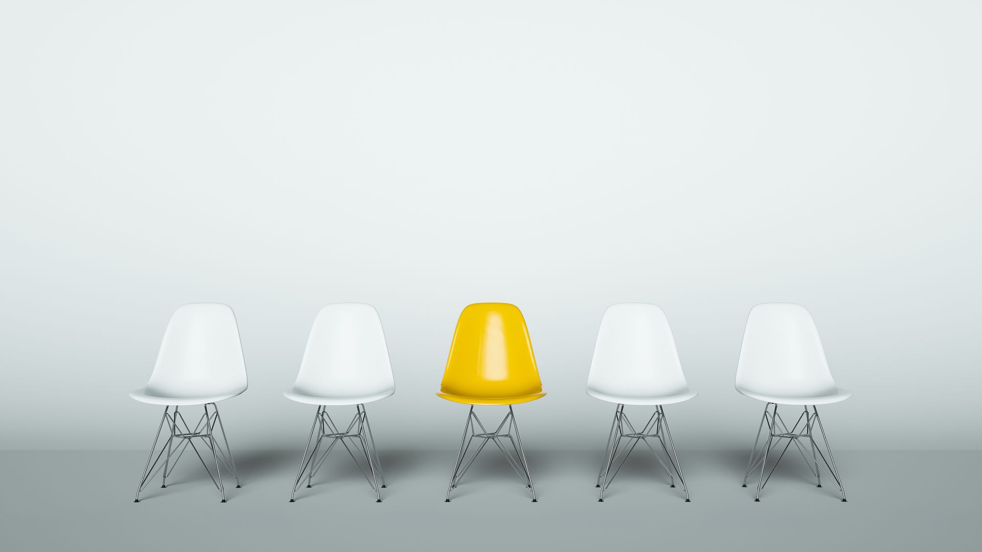 Eine Reihe von fünf Stühlen im Stil der Mitte des 20. Jahrhunderts vor einer schlichten Wand, wobei