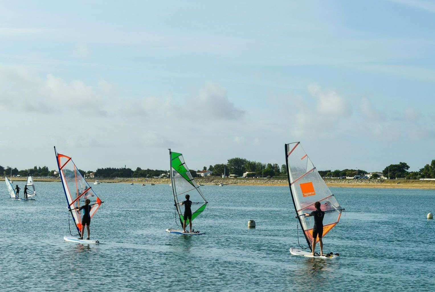 Trois personnes faisant de la voile.