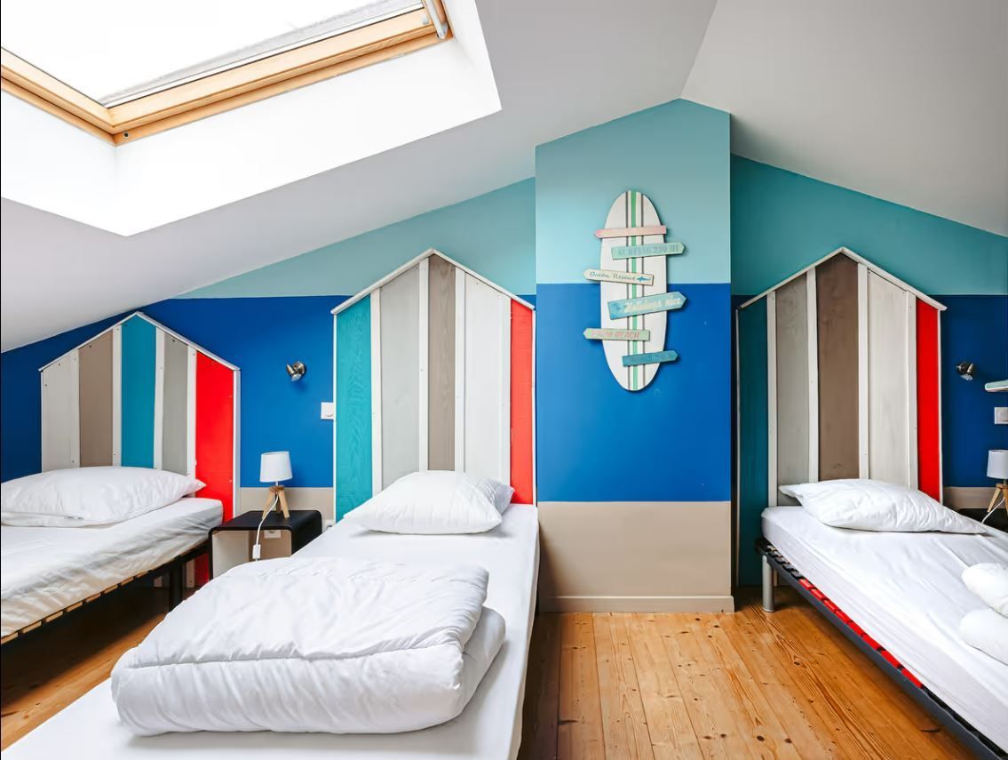 Trois lits dans une chambre avec un décor marin.