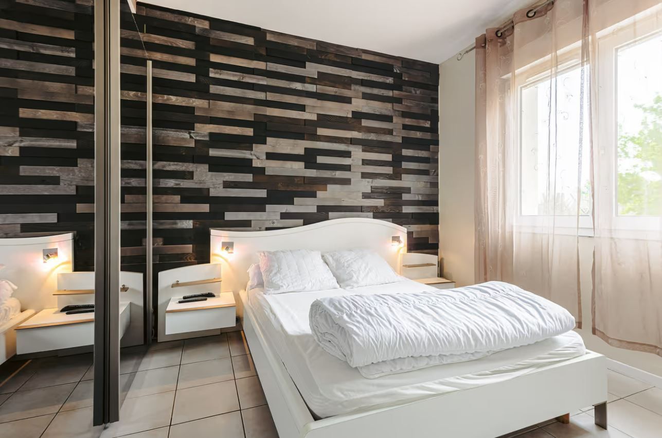 Une chambre avec une fenêtre décorée d'un rideau.
