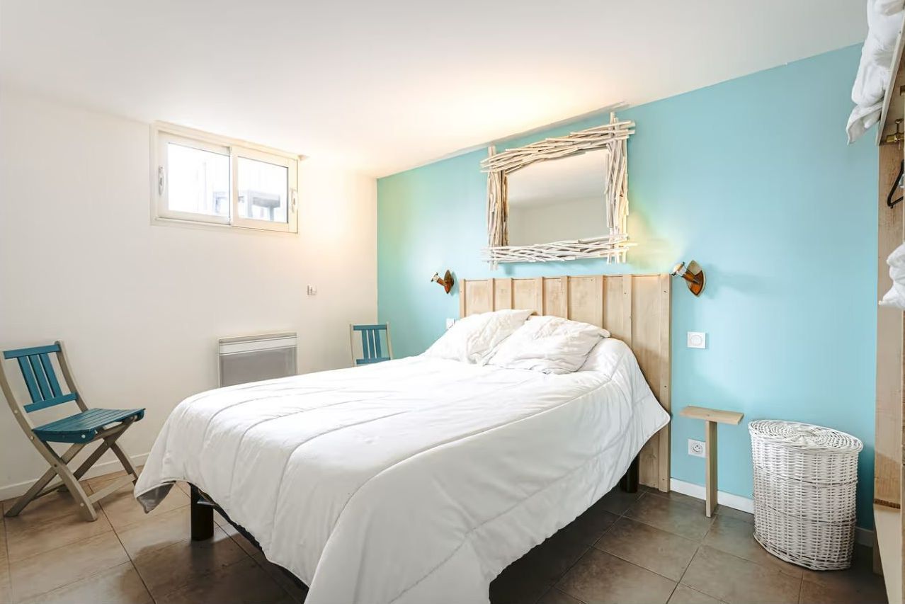 Un lit double dans une chambre avec un mur bleu turquoise.
