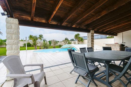 Une terrasse couverte donnant sur une piscine chauffée.