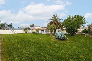 Un jardin devant une résidence de vacances.