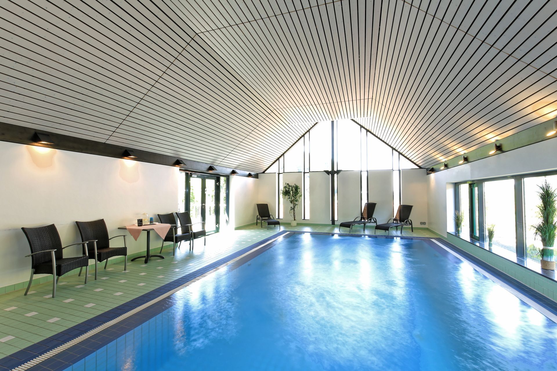 Ein großes Hallenbad mit Stühlen und Tischen drumherum