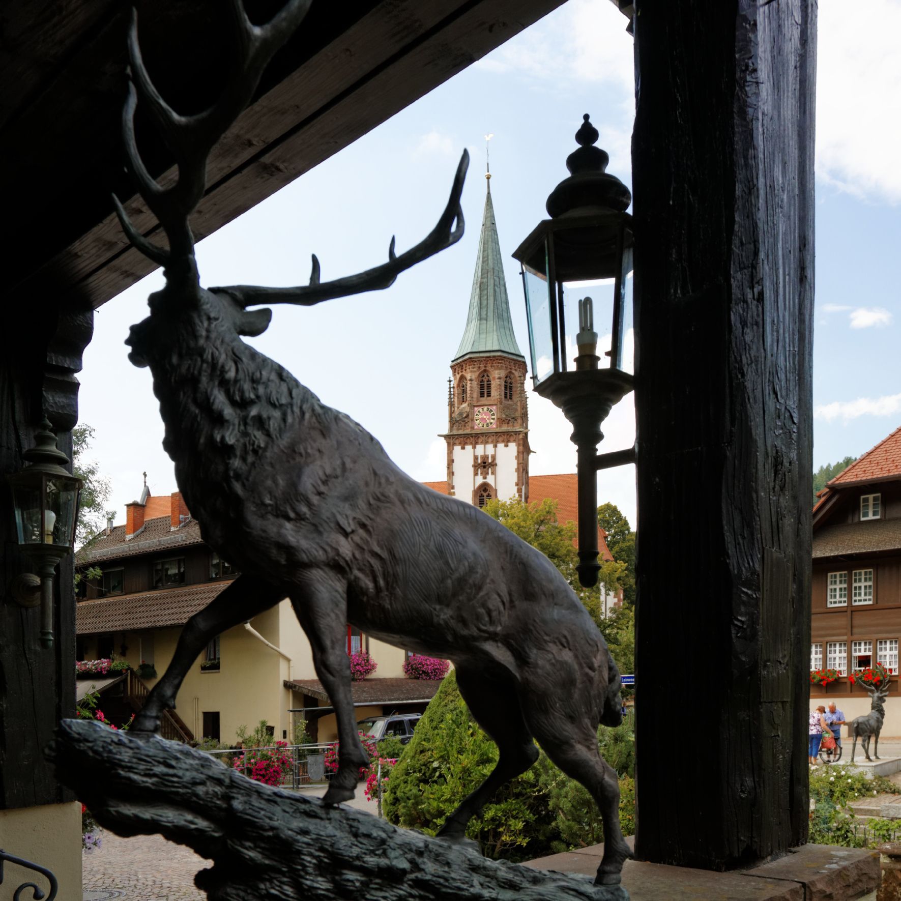 Eine Statue eines Hirsches mit einer Kirche im Hintergrund
