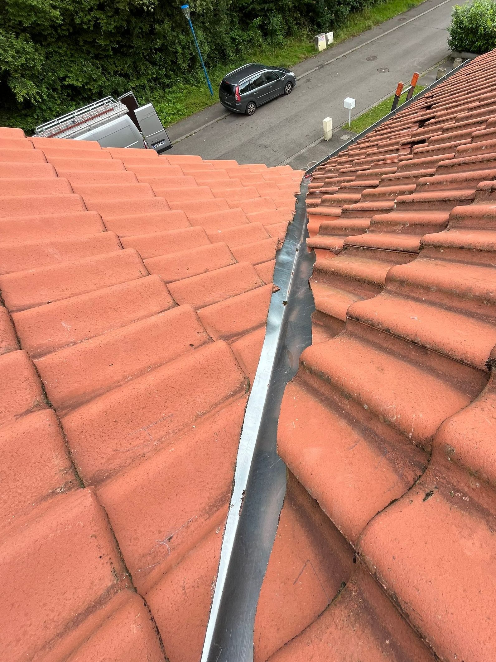 Bande de mitoyenneté en zinc sur un toit en tuiles