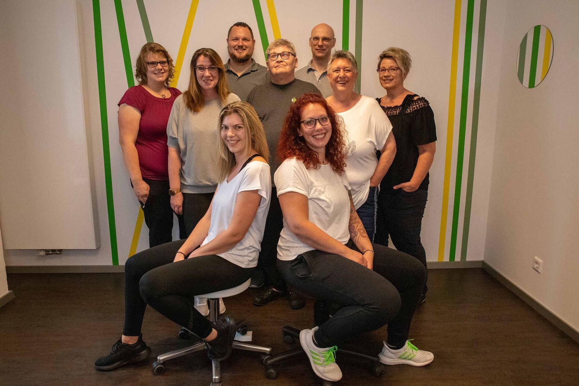 Eine Gruppe lächelnder Menschen posiert für ein Foto in einem Innenraum.