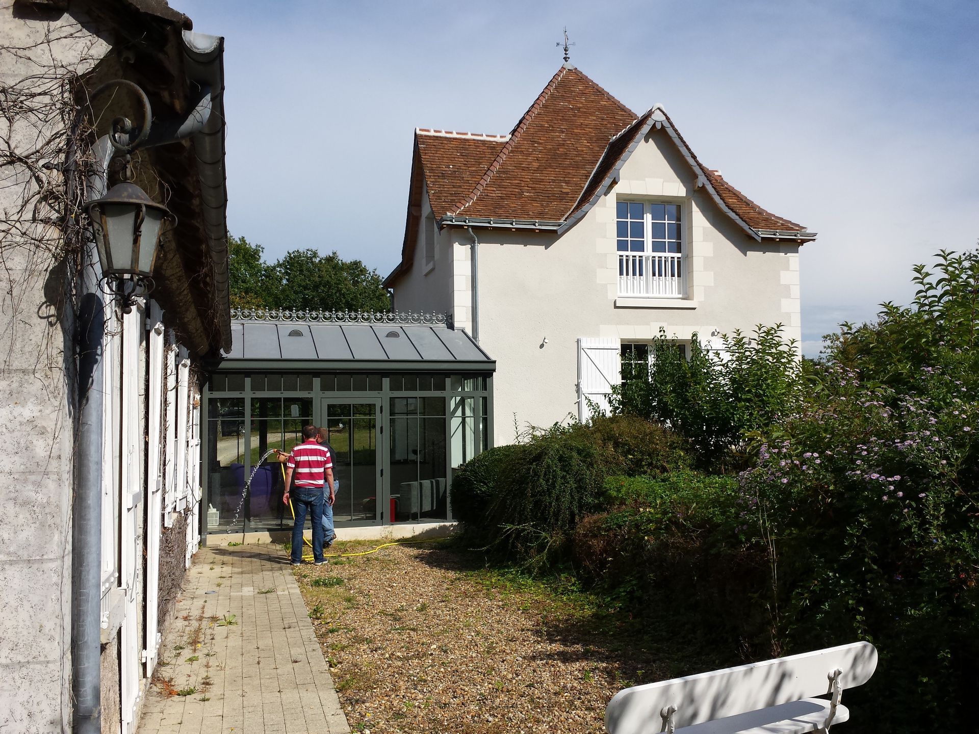 Extension de maison vitrée entre deux parties en béton d'une maison de campagne