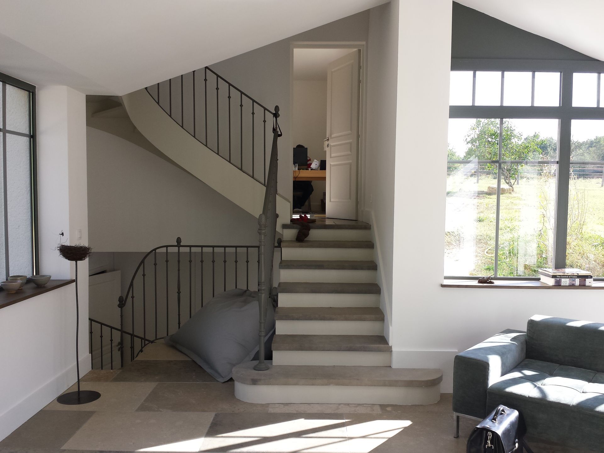 Escalier qui donne sur une porte dans un étage intérmédiaire après la rénovation d'un intérieur de maison