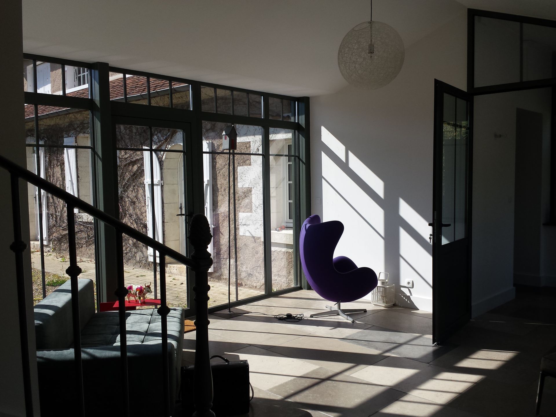 Intérieur d'une extension de maison aménagée avec escalier, mobilier et sol neuf