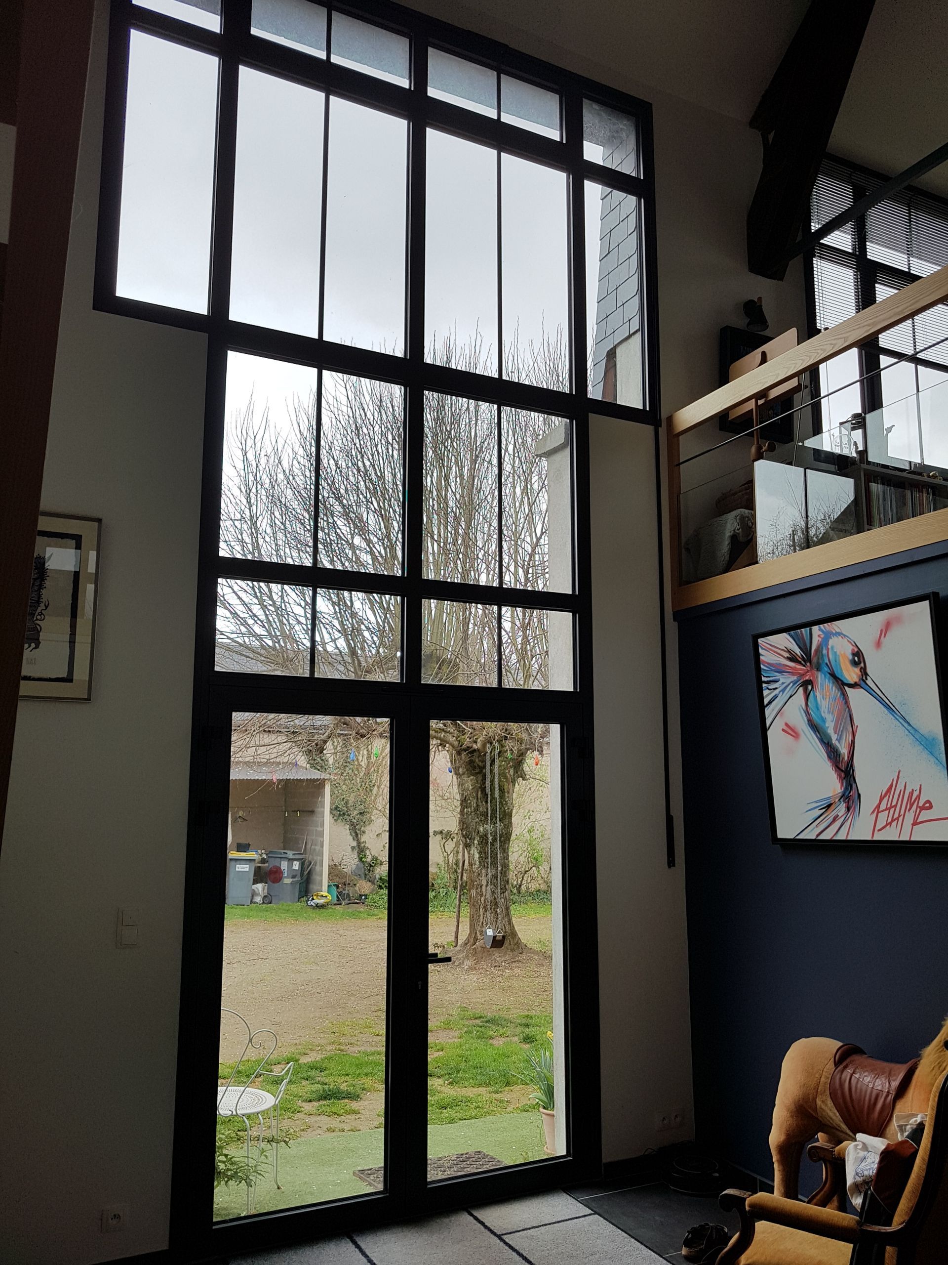 Grande baie vitrée dans l'entrée d'une extension de maison