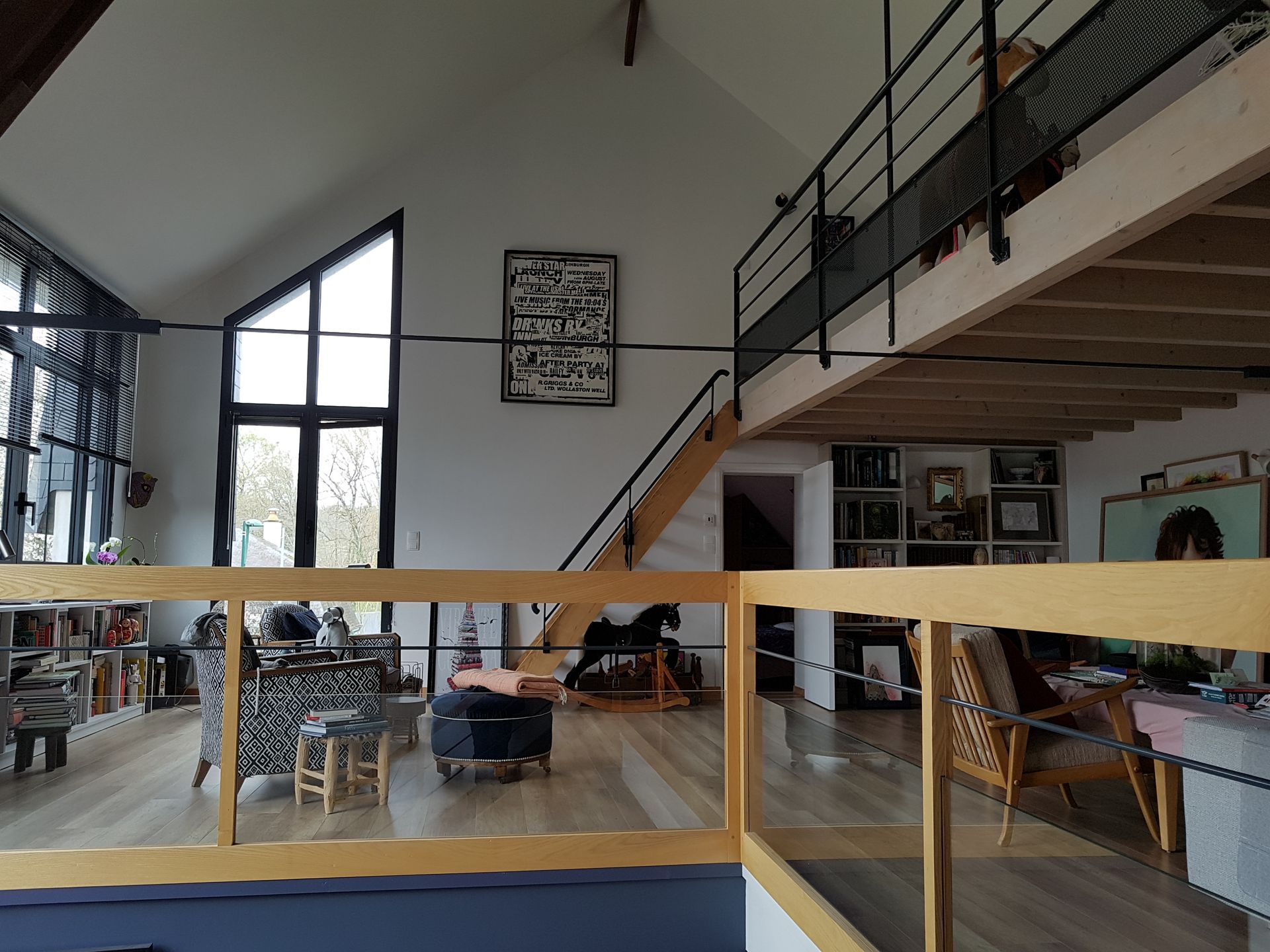 Premier étage d'un aménagement dans une grange réhabilitée avec sol et garde-corps en bois