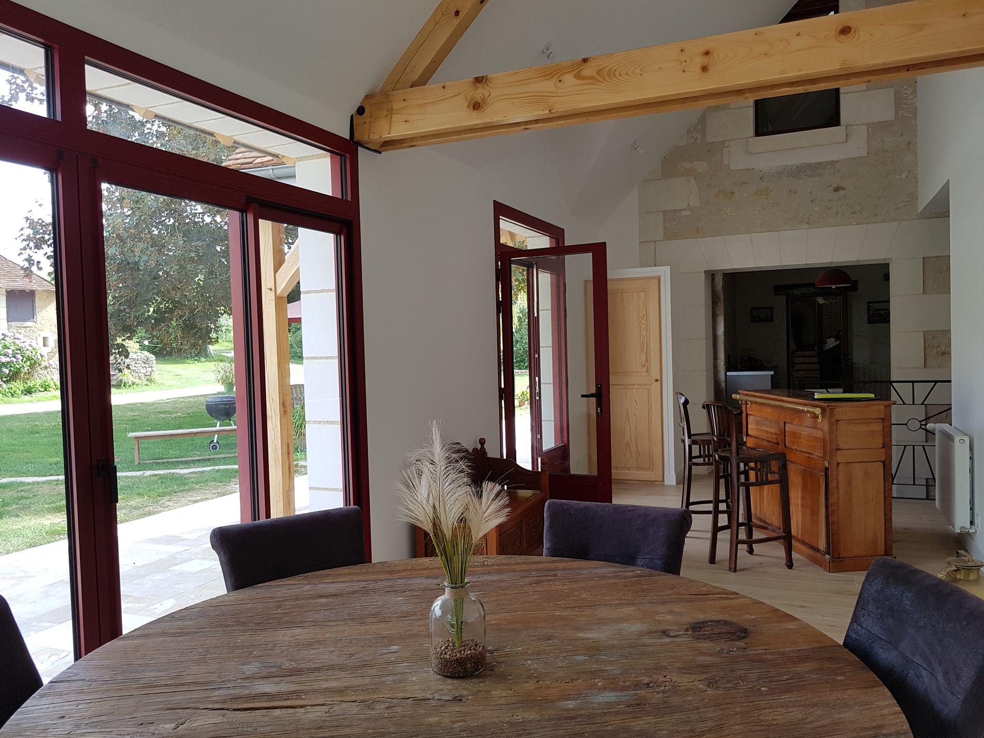 Pièce à vivre dans une extension de maison avec table de repas et comptoir en bois