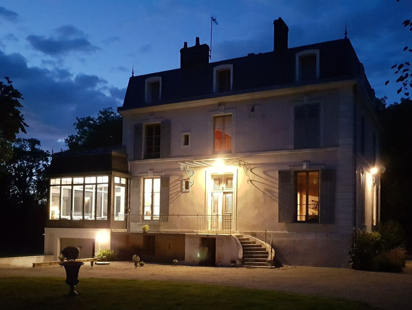 Devanture d'une maison de campagne de nuit avec une nouvelle extension de maison à gauche