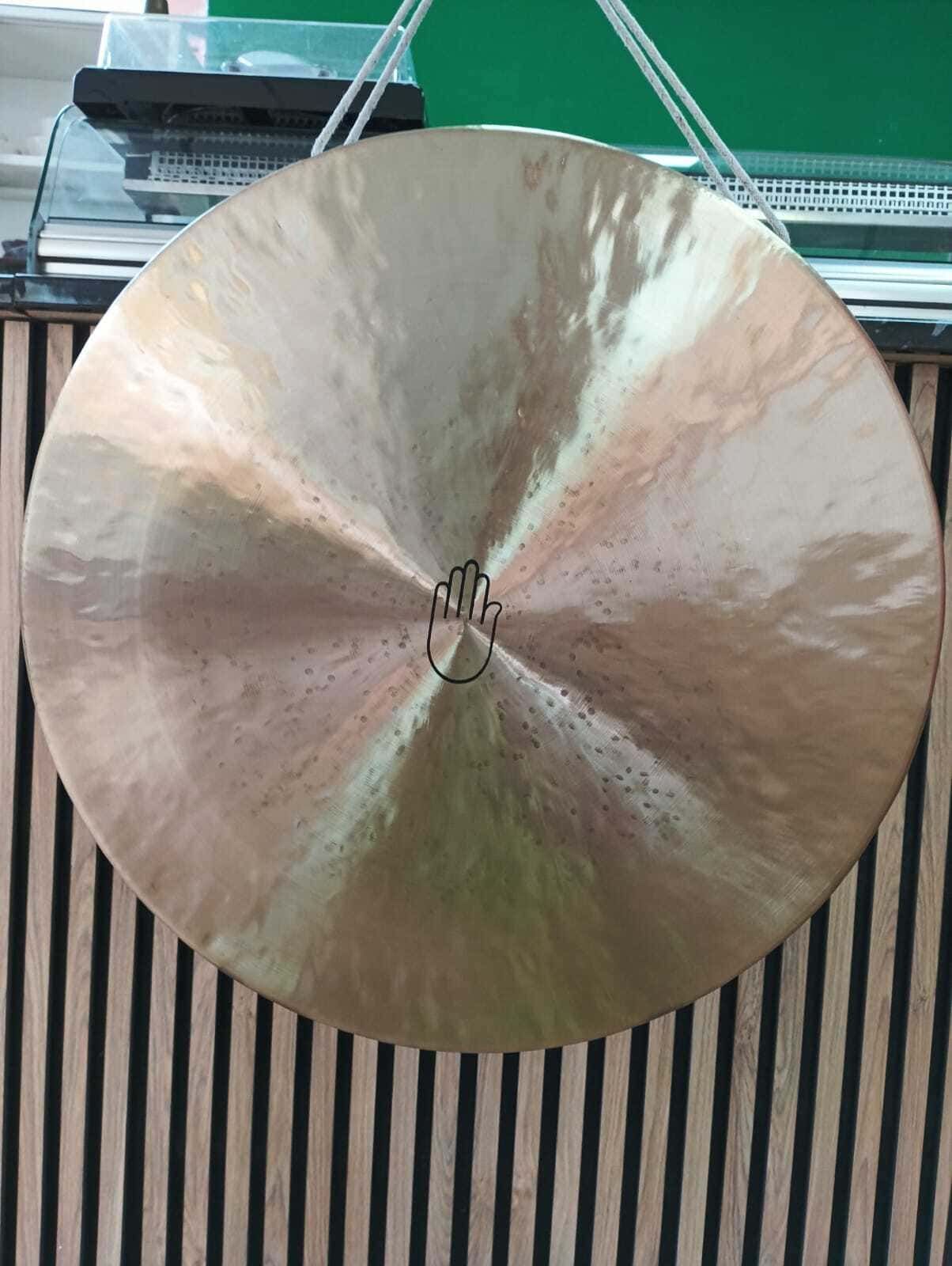 Un gran gong está colgado en una pared de madera.
