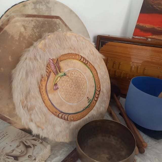 Un tambor con un colibrí sobre él se encuentra sobre una mesa.