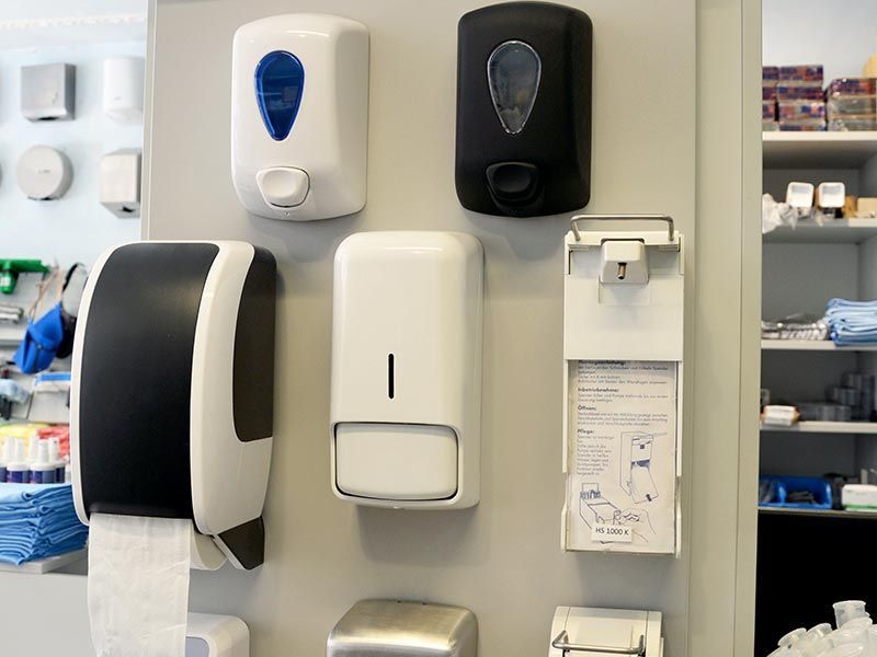 Eine Wand mit einer Reihe von Seifenspendern daran