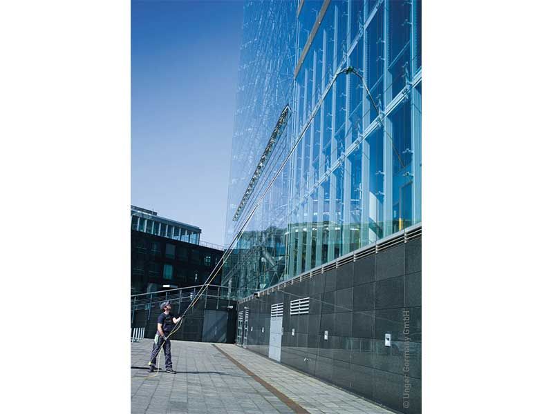 Ein Mann putzt die Fenster eines hohen Gebäudes